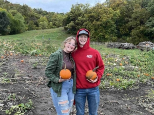 Woman and man holding pumpkins