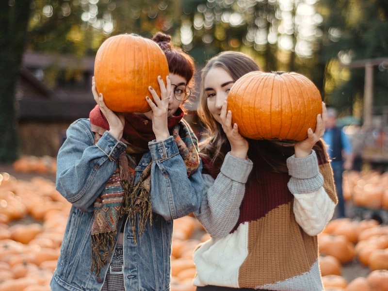Girls holding up pumpkins