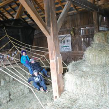 People sitting in spiderweb made from rope