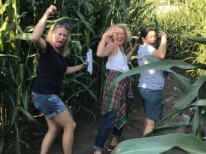 Three women having fun while navigating corn maze
